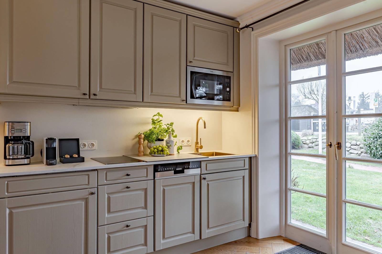 Kitchen with light cabinets, sink, and view of garden