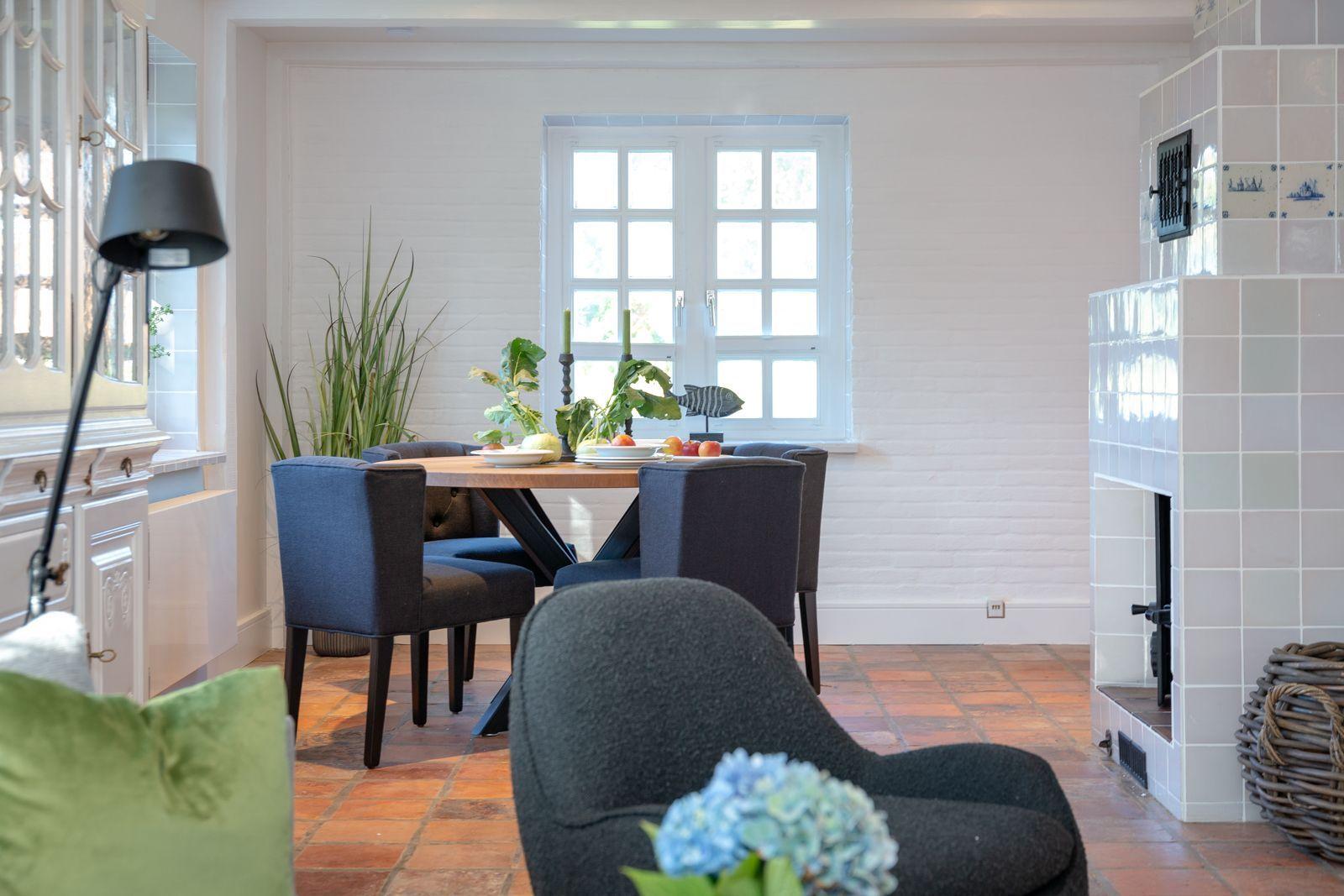 Dining room with table, chairs, and tiled fireplace on the wall.
