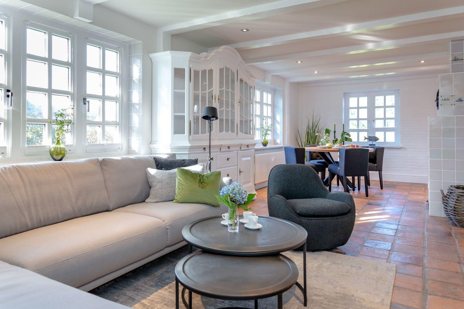Living and dining area with sofa, chairs, and wooden floor.