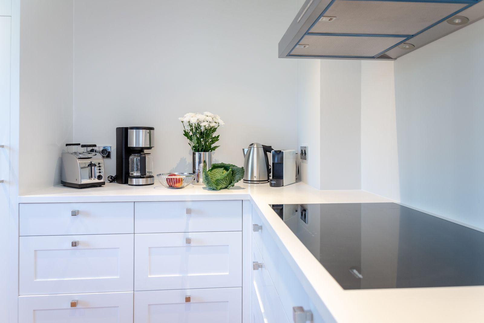 Kitchen with white cabinets, cooktop, and kitchen appliances.