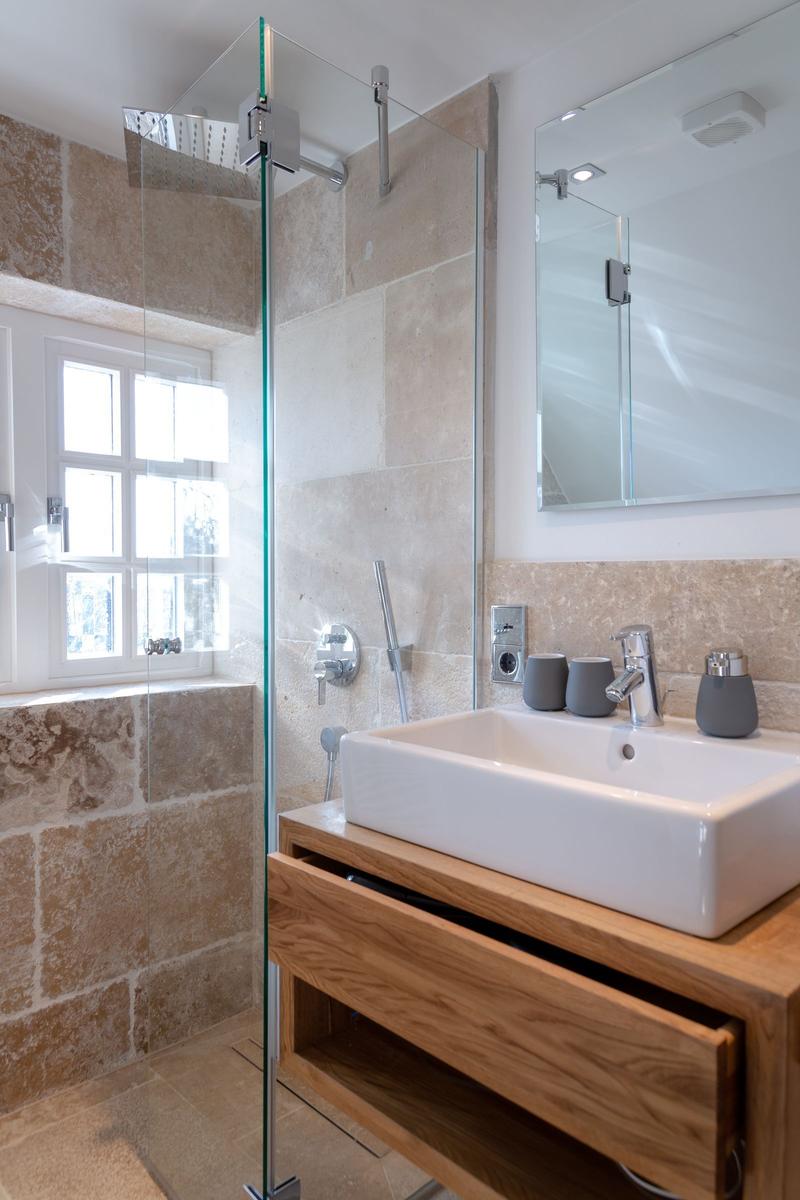 Bathroom with shower, sink, and window