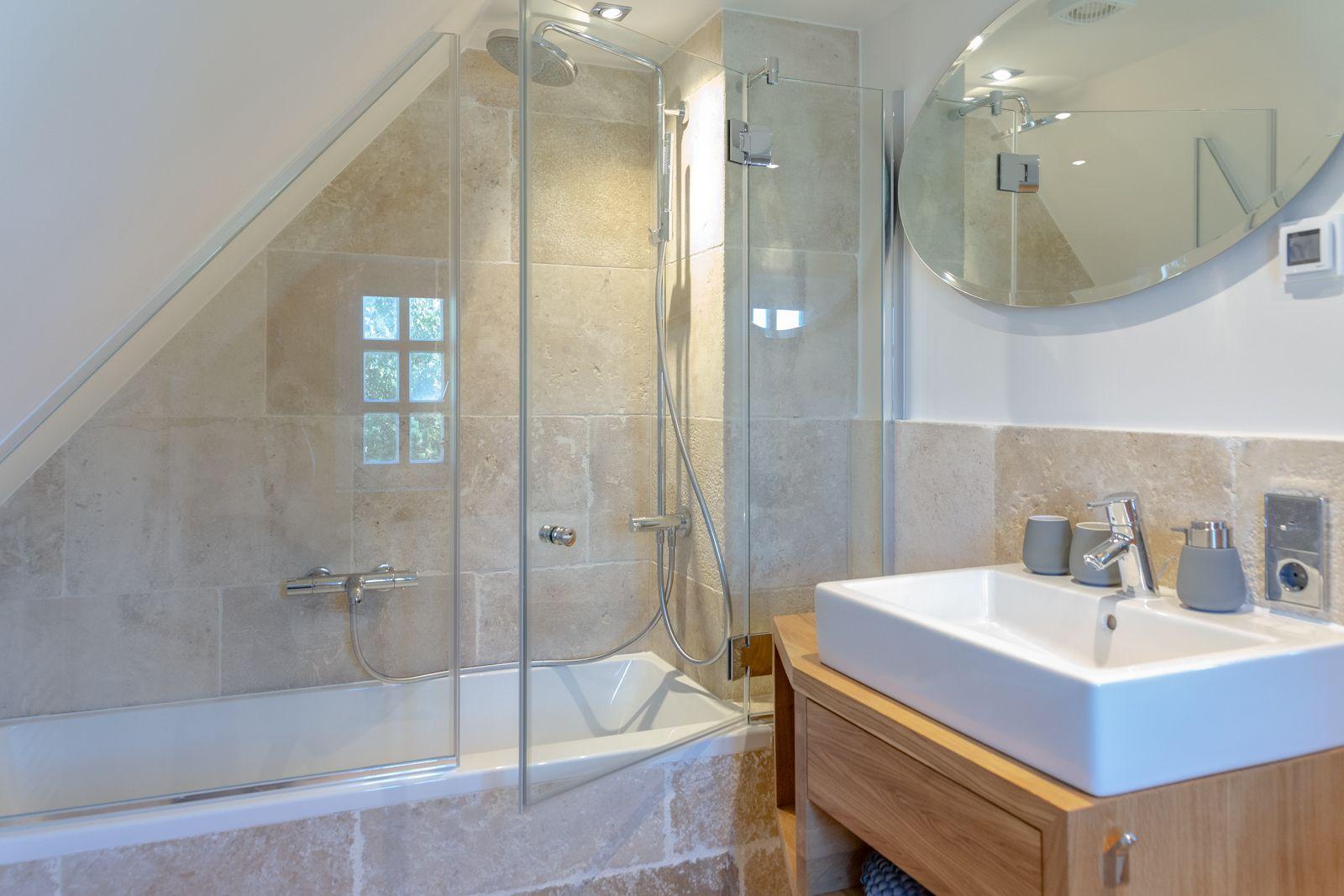 Shower with glass enclosure, sink and mirror in a bathroom