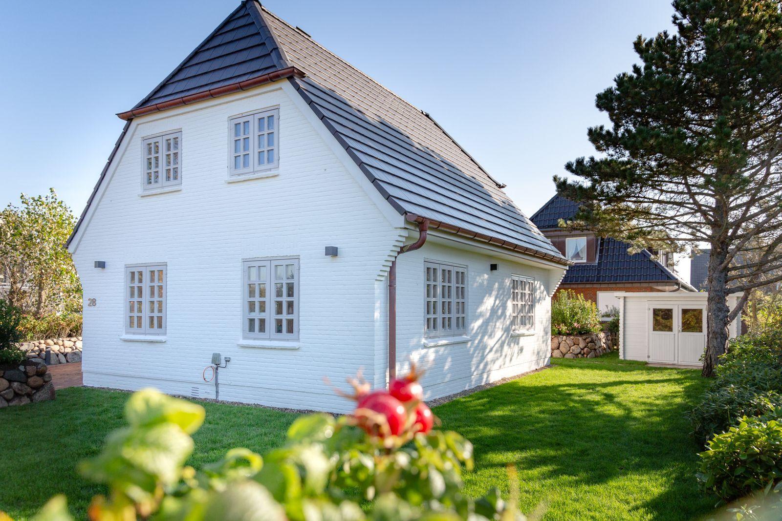 White villa with gray roof and green garden. House number 28 visible.