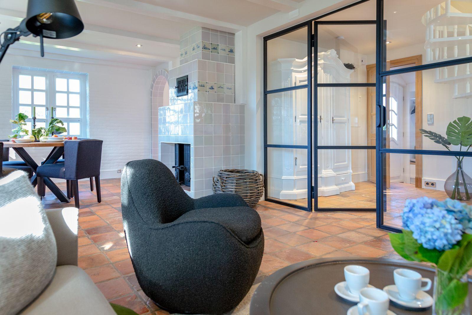 Living room with seating, fireplace, and glass wall to the kitchen.