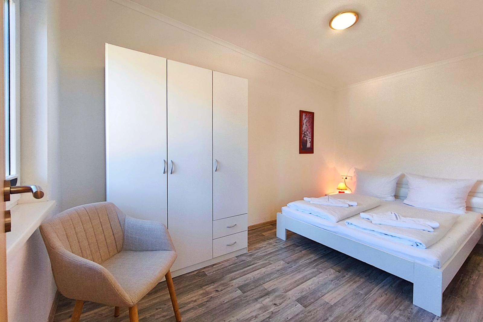 Erstes Schlafzimmer mit komfortablem Doppelbett in Loddin