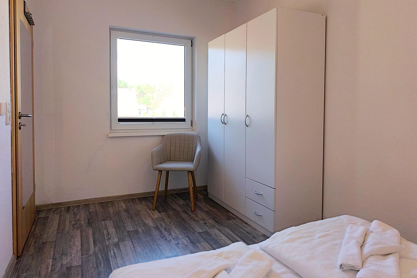 Seitenansicht des gemütlichen Doppelbettes im ersten Schlafzimmer