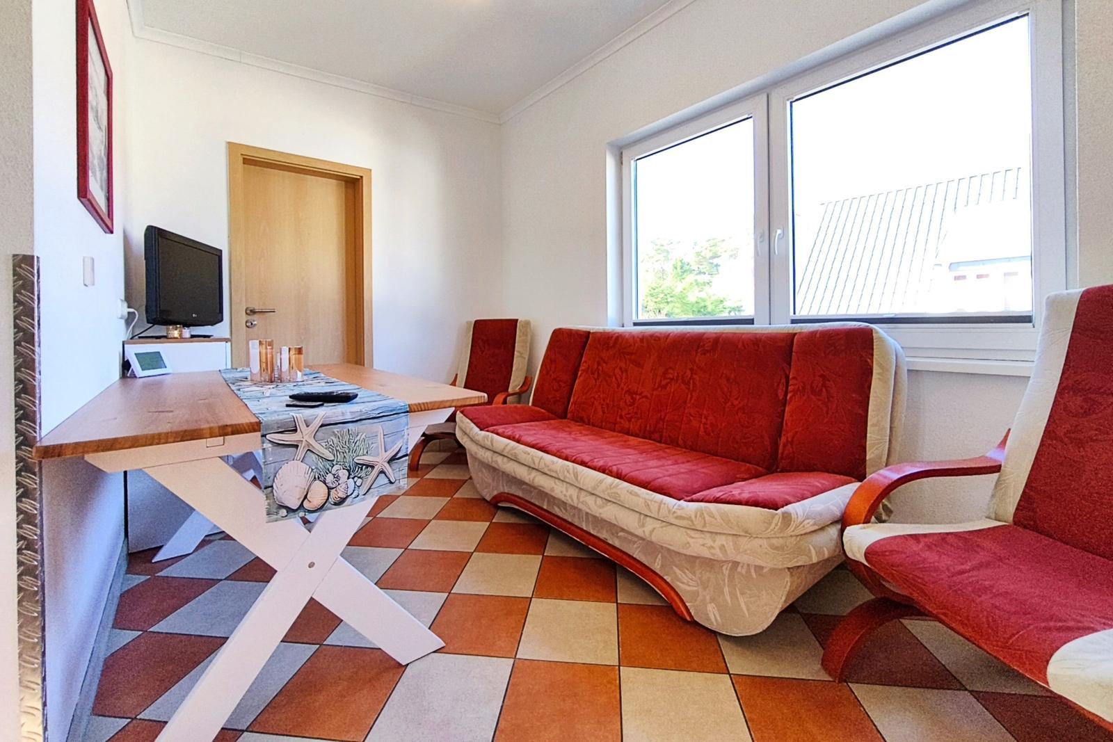 Gemütliches Wohnzimmer mit heller Couch in der Fewo Reimann 1