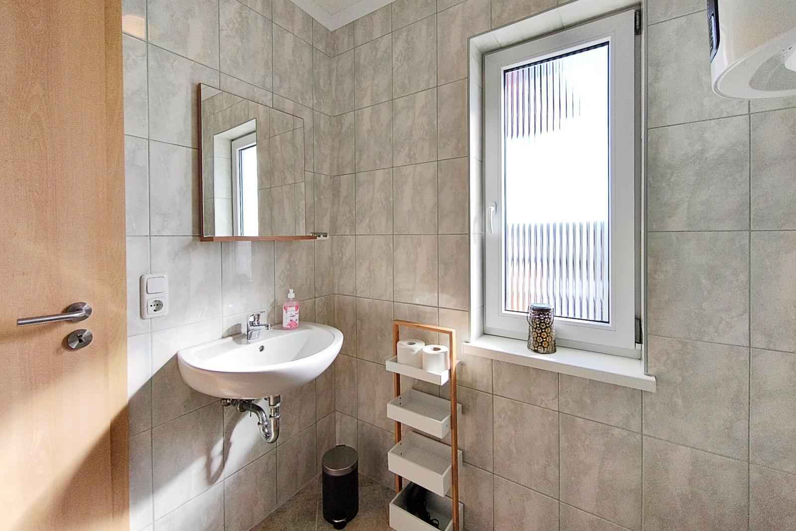 Sauberes Badezimmer mit Fenster und viel Licht in Loddin