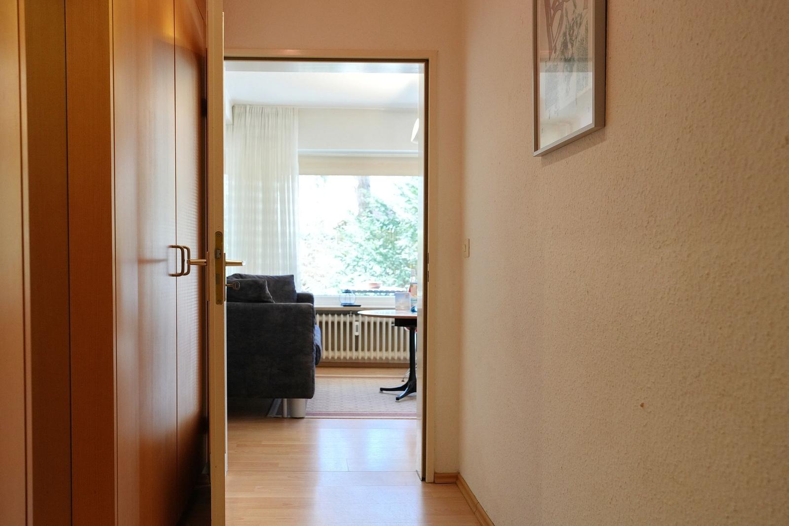 Durchgang zur Wohnfläche mit Sofa und Fensterblick