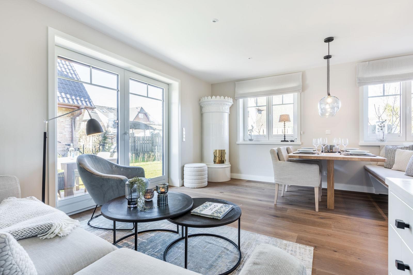 Living and dining area with wooden floor, windows, and modern furnishings.