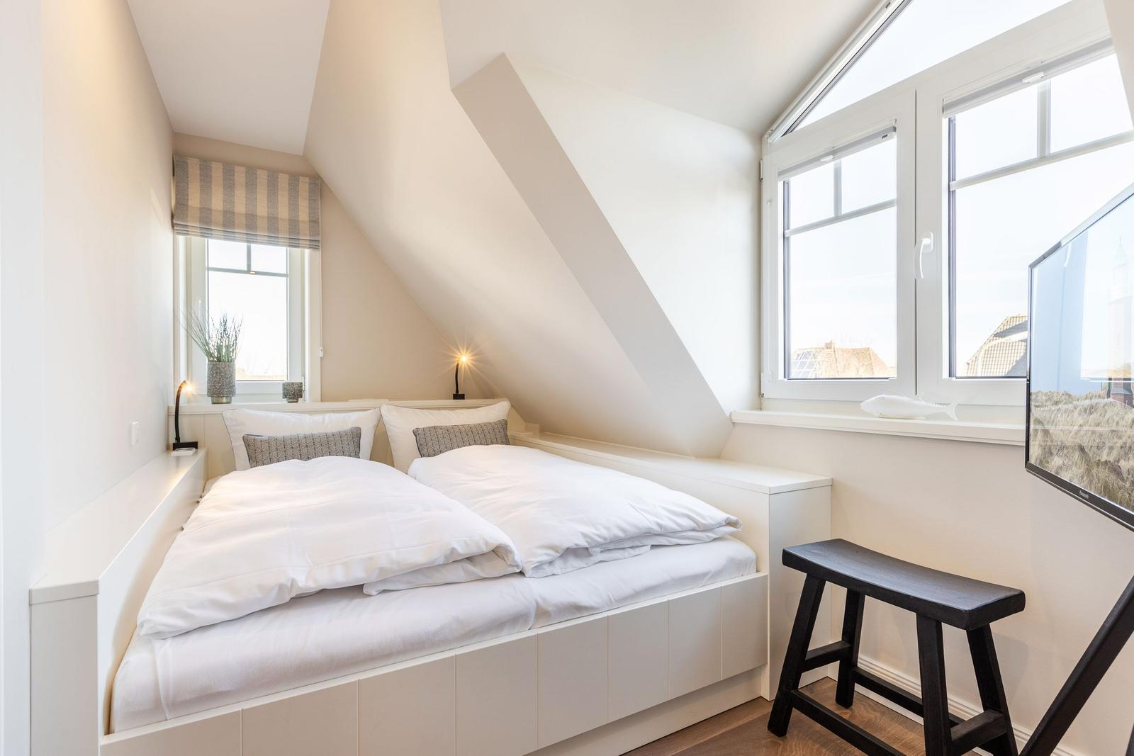 Room with double bed, windows, and TV