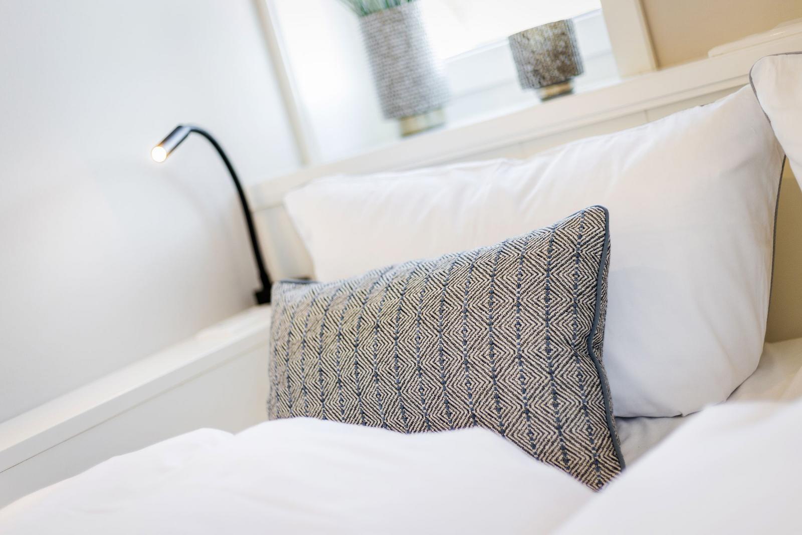 Bed headboard with pillows and bedside lamp