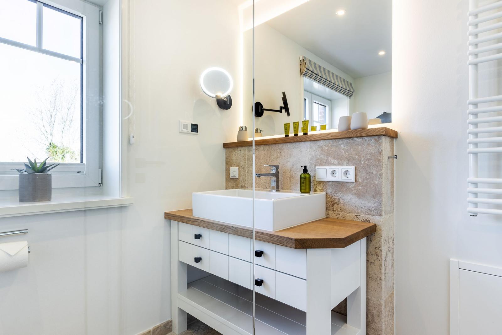 Bathroom with sink, mirror and window.