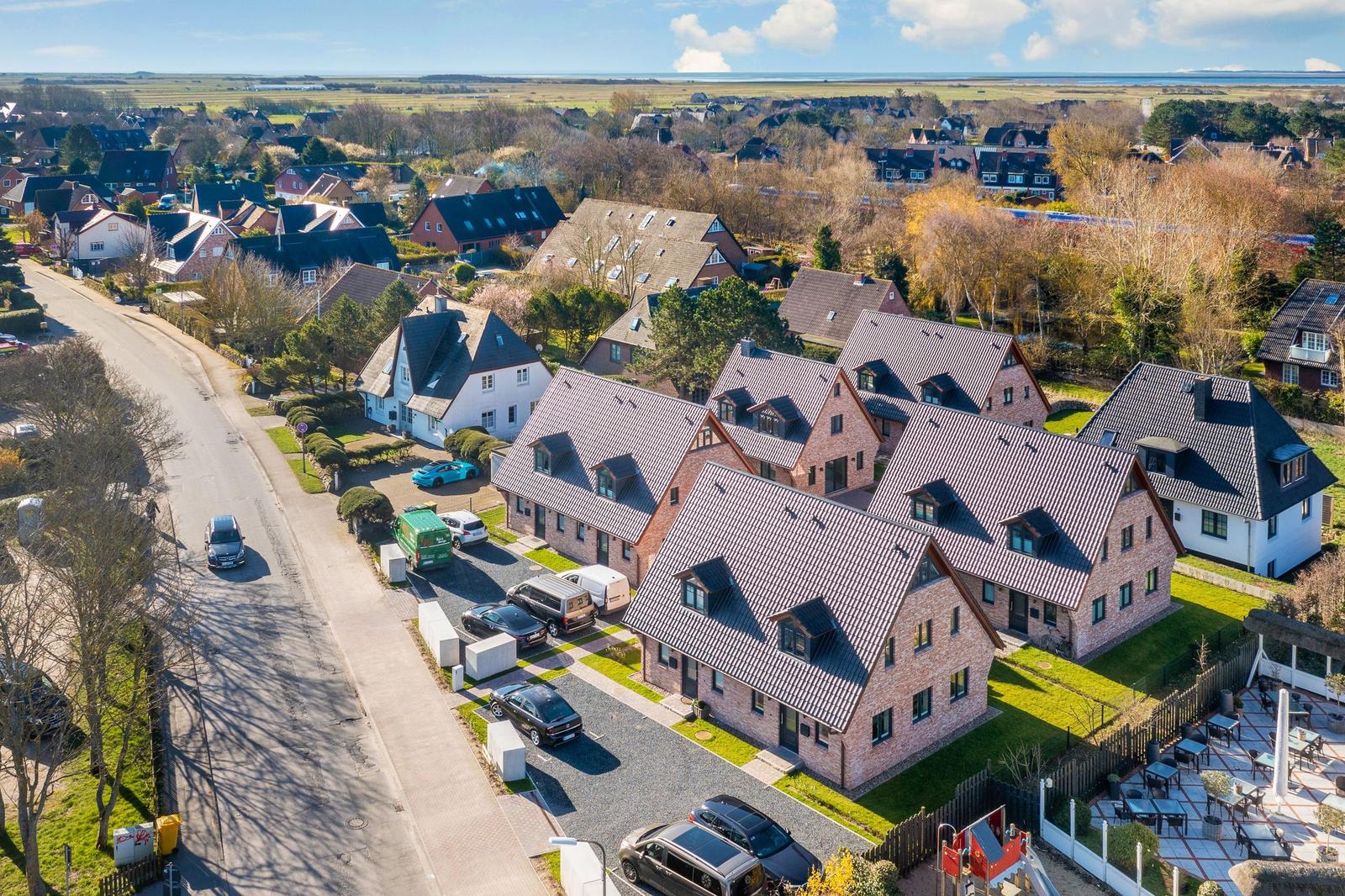 Houses with dormers and green areas in a residential area.
