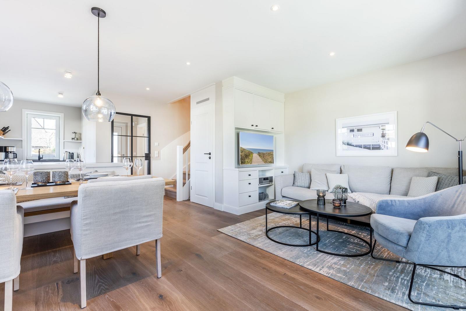 Living and dining area with sofa, table, and TV.