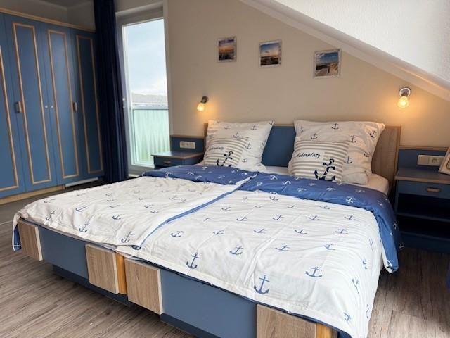 Schlafzimmer mit Bett, Nachttischen und Garderobe unter Dachschrägen