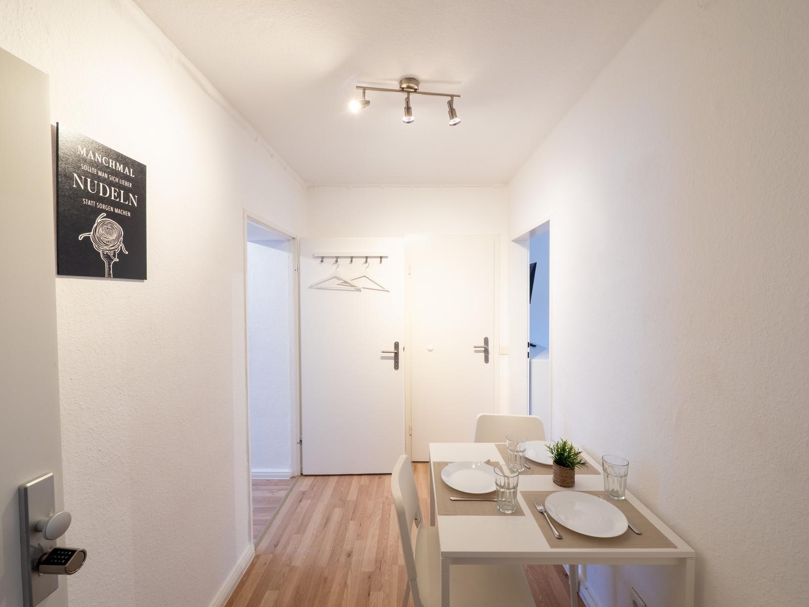 Essbereich mit Tisch, Stühlen und Dekoration. Hintergrund: Tür und Wanddekoration.