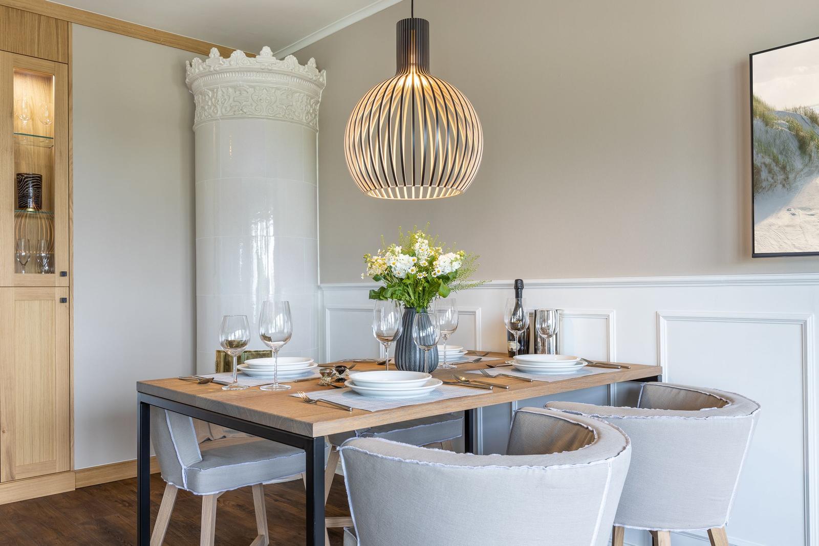 Esstisch mit Stühlen, Pendelleuchte und Blumenvase