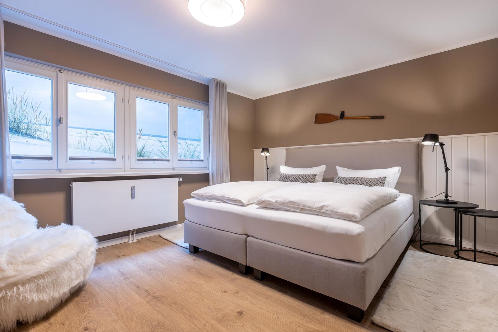 Schlafzimmer mit großem Bett und Blick auf Strand