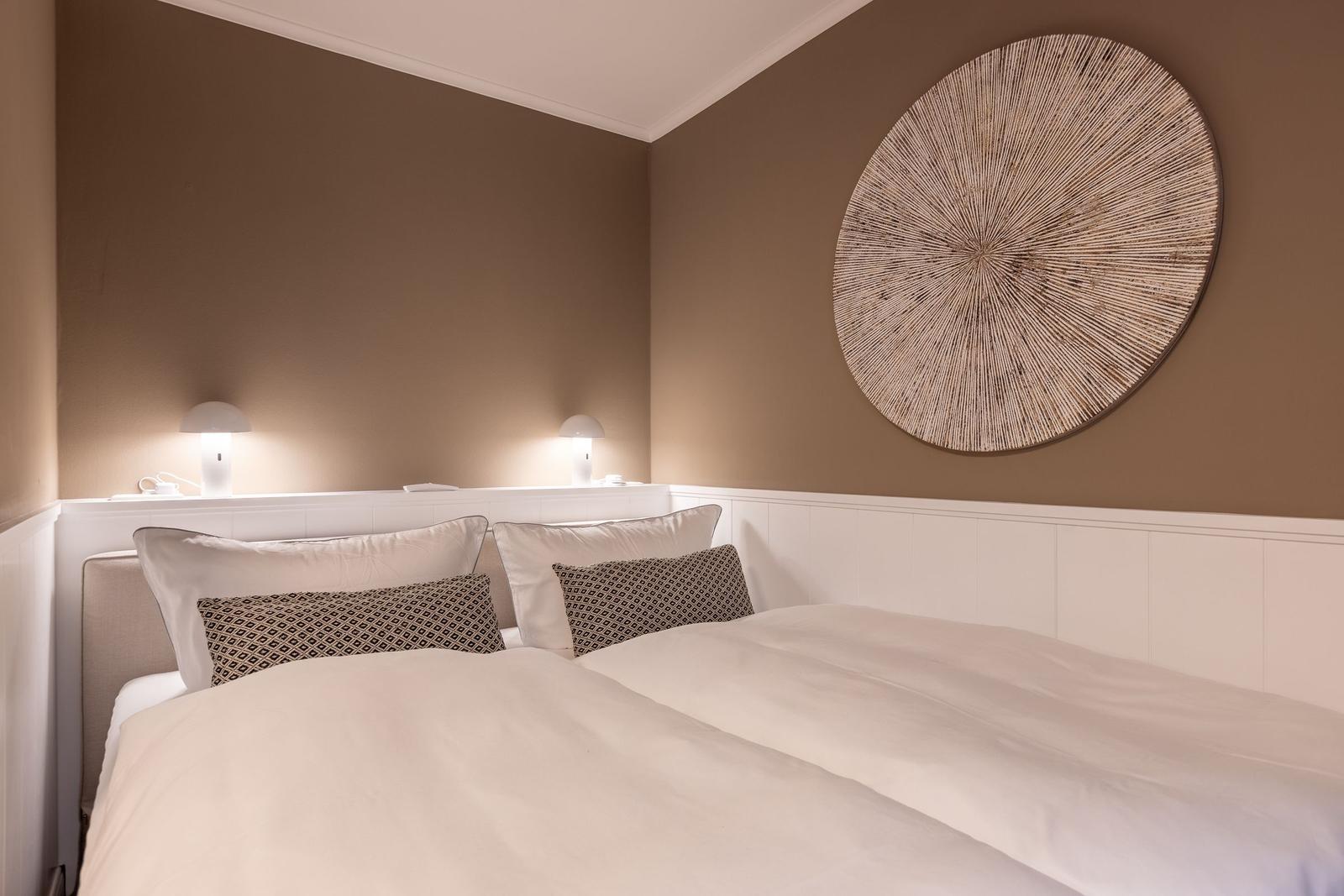 Schlafzimmer mit Bett, Kissen und Wanddekoration