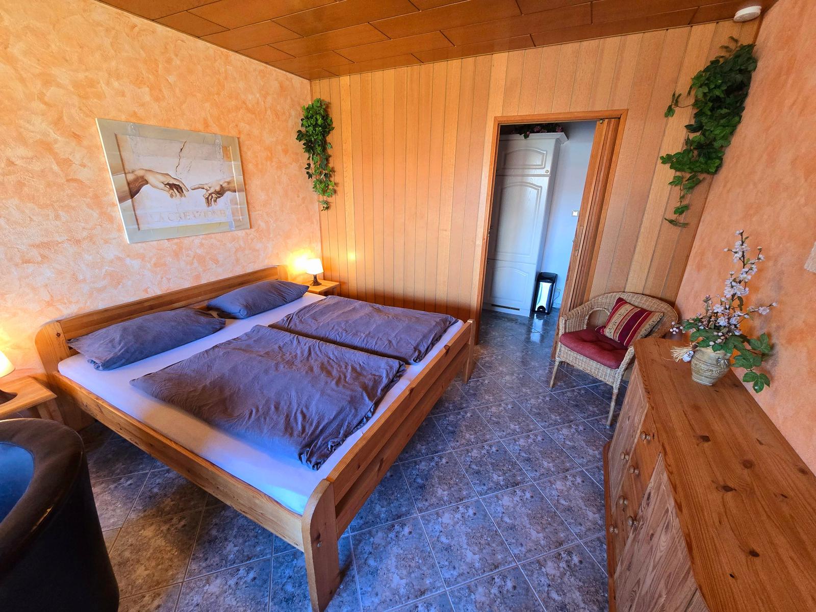 Heller Wohnbereich mit Doppelbett, Sitzecke und einladendem Ambiente zum Wohlfühlen.