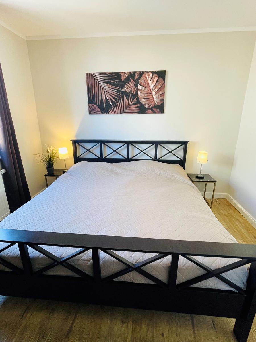 Schlafzimmer mit Bett, Nachttischen und Wandbild
