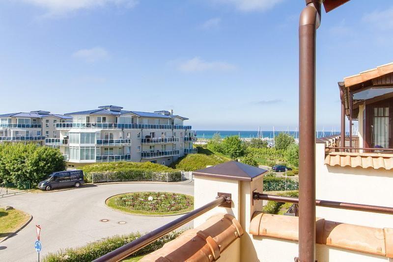 Blick von Balkon auf Wohnhaus und Meer mit Booten