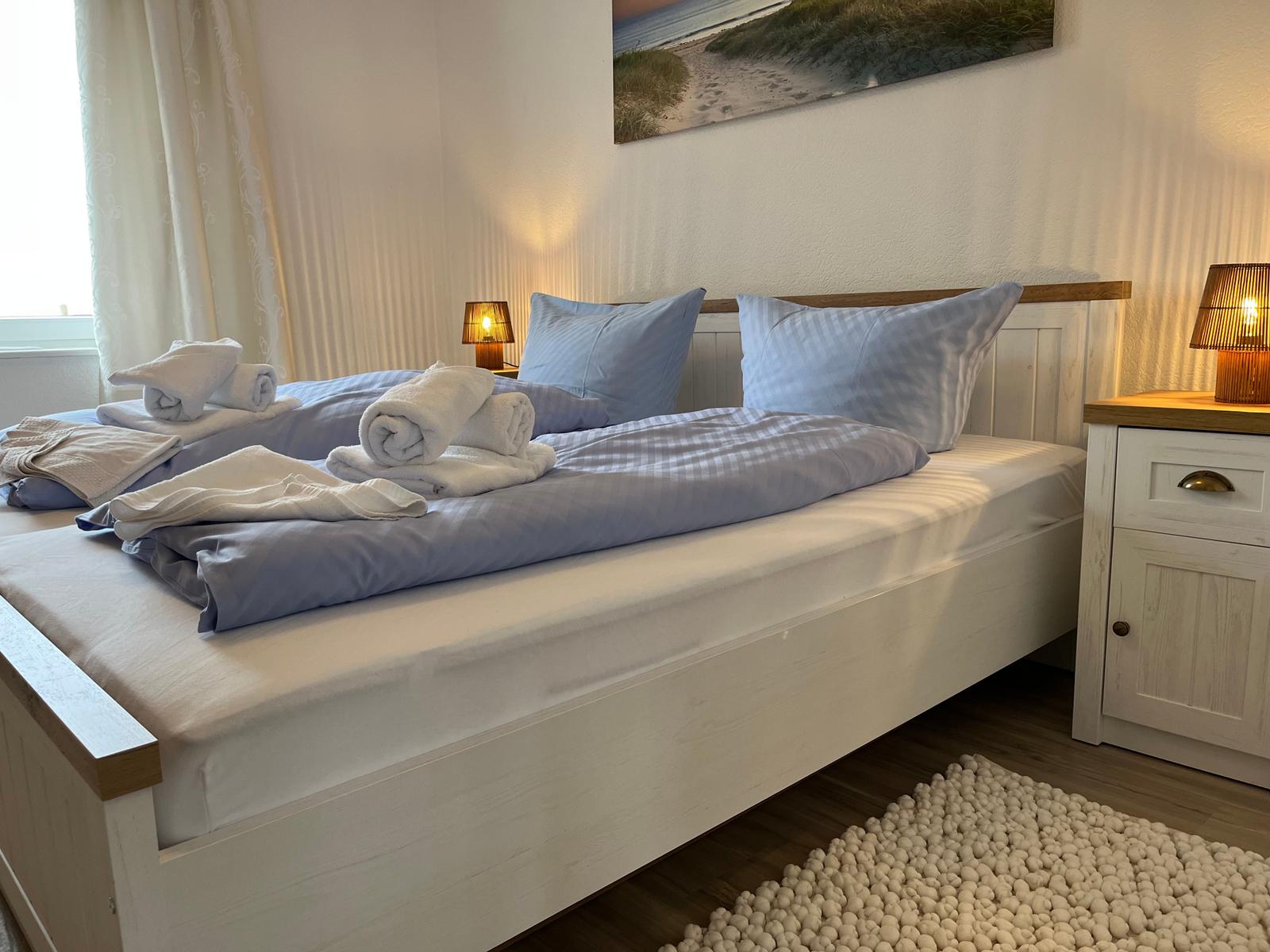 Schlafzimmer mit Bett, Nachttisch und Wandbild