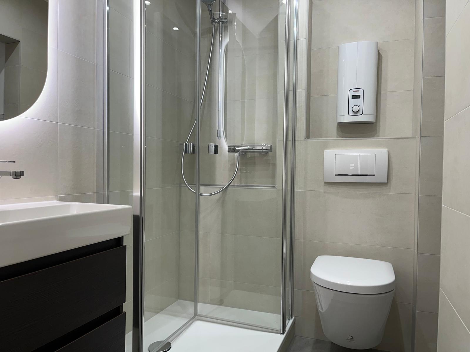 Badezimmer mit Dusche, Waschbecken und Toilette