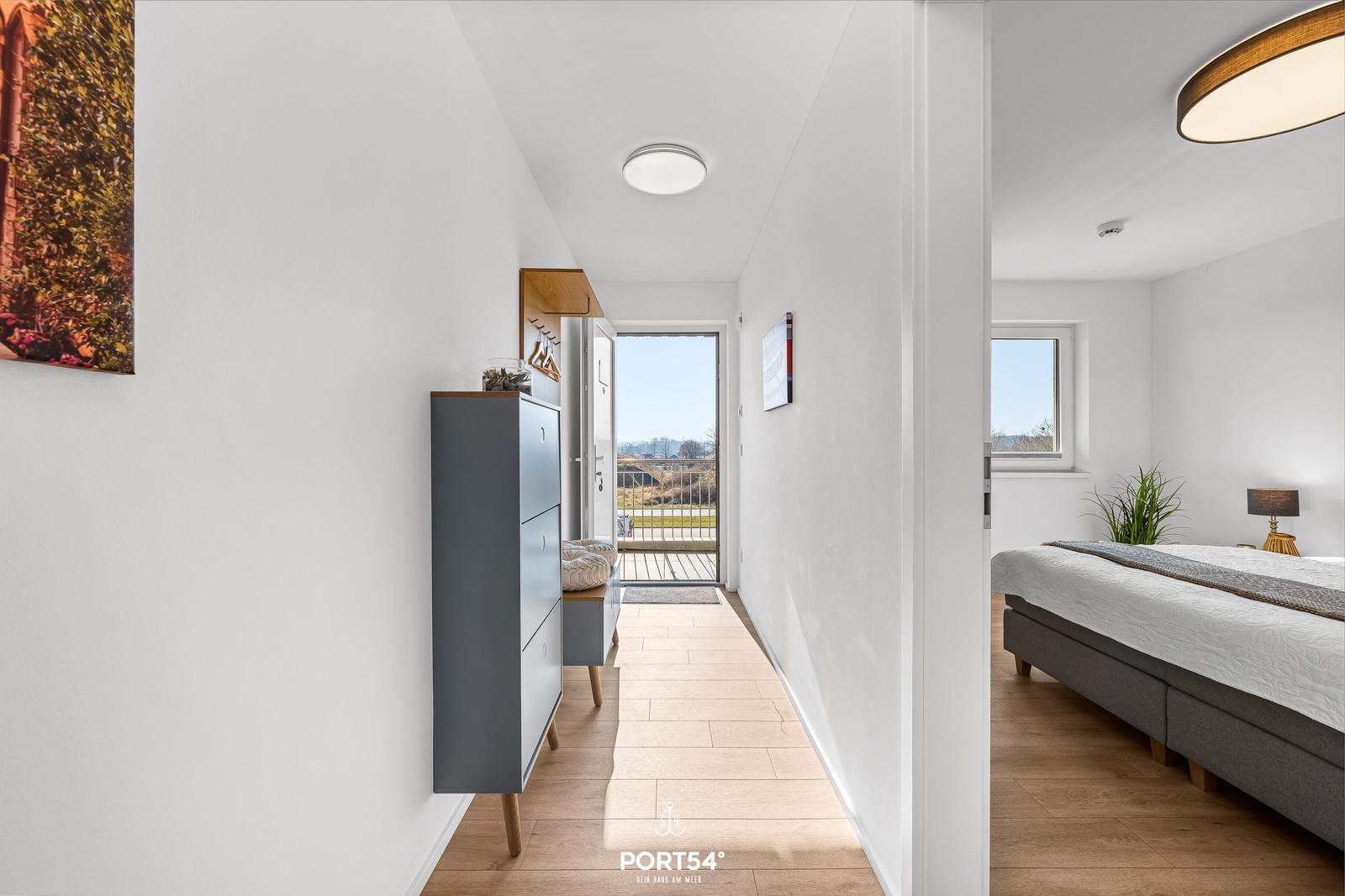 Flur mit Schlafzimmer und Balkonansicht. Moderne Einrichtung und helles Ambiente.