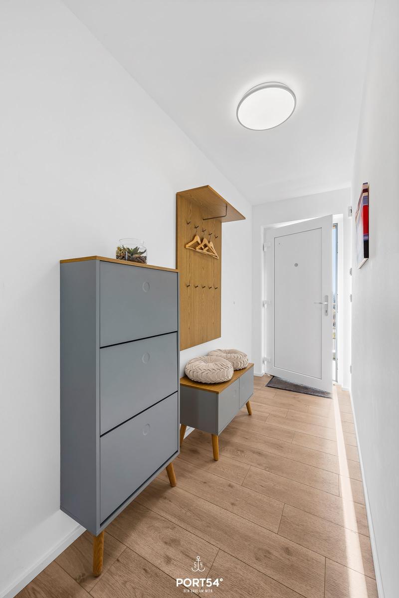 Eingangsbereich mit Schuhschrank, Hocker und Kleiderständer.