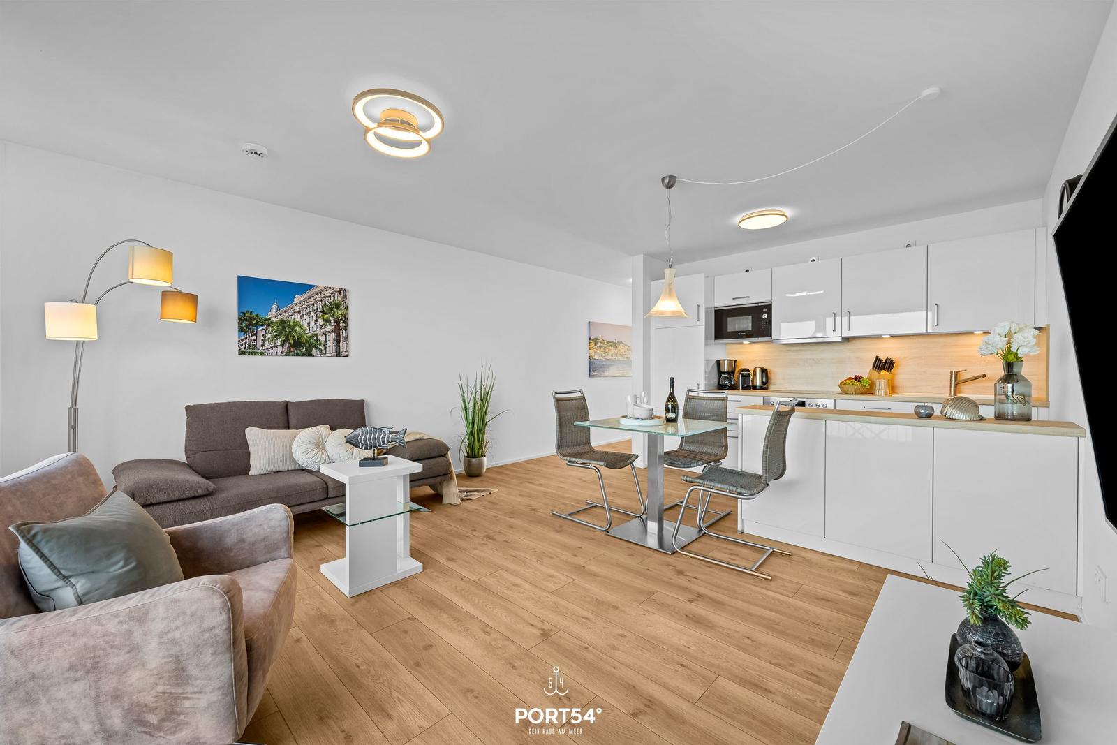 Wohn- und Küchenbereich mit Sofa, Esstisch und moderner Küche.