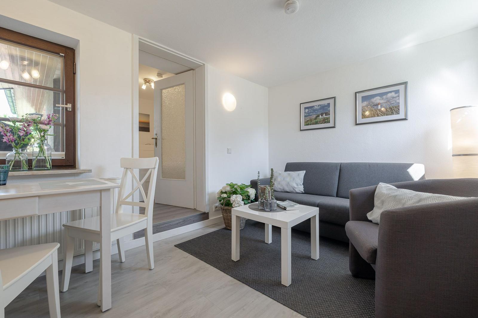 Wohn- und Essbereich mit Sofa, Tisch und Fenster