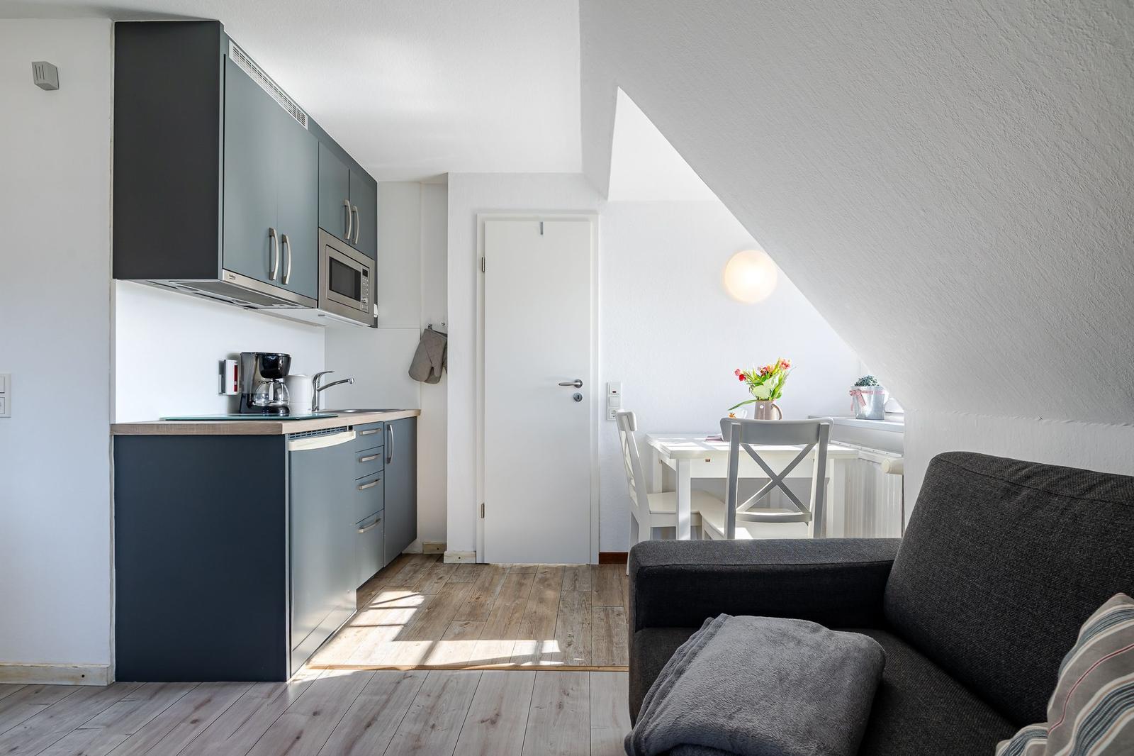 Küche mit Essbereich und Sofa unter Dachschrägen
