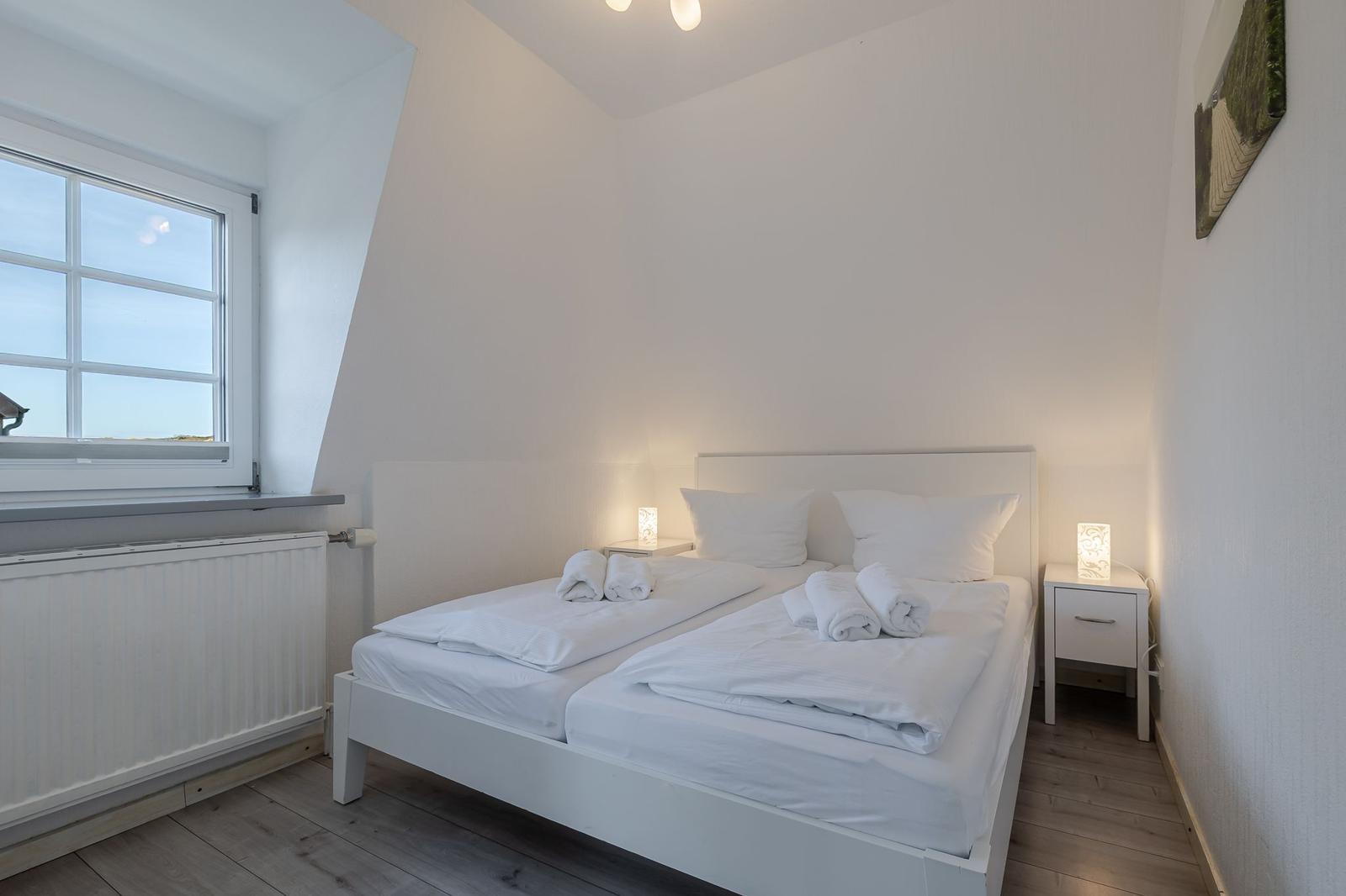 Schlafzimmer mit Doppelbett, Fenster und Nachttischen