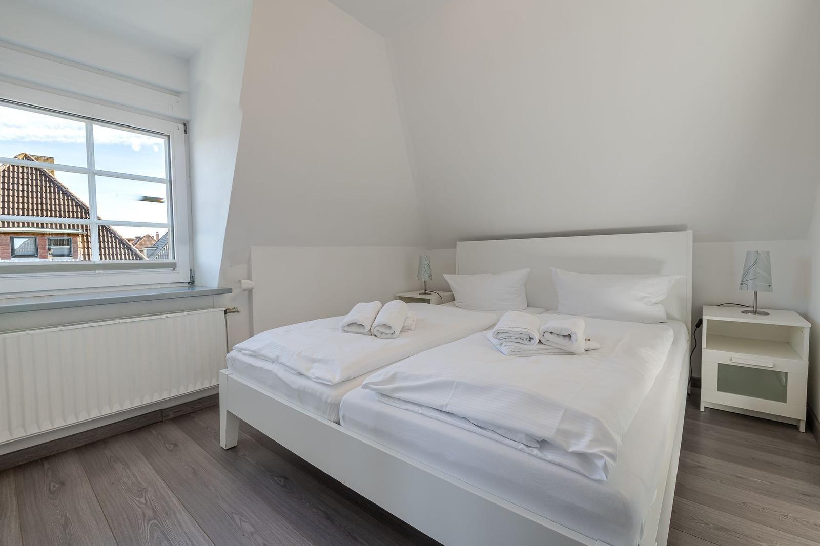 Schlafzimmer mit Doppelbett, Fenster und Nachttischen