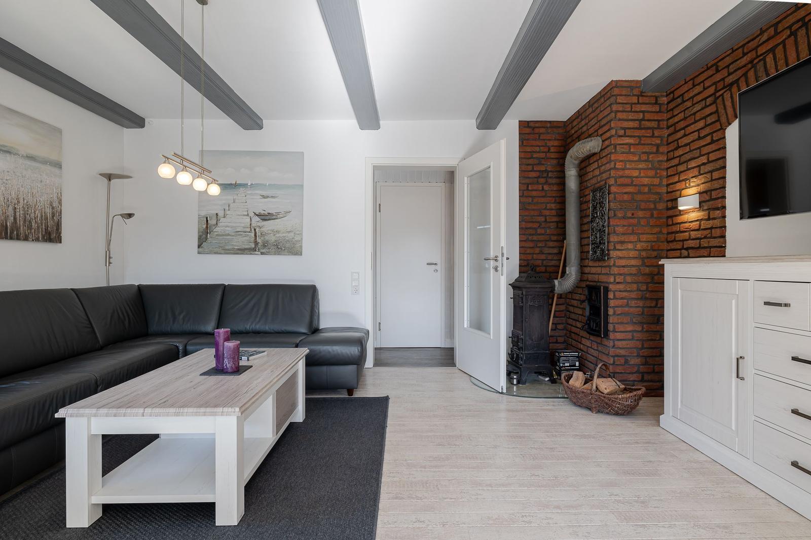 Wohnzimmer mit Sofa, Couchtisch und Kaminwand aus Backstein.