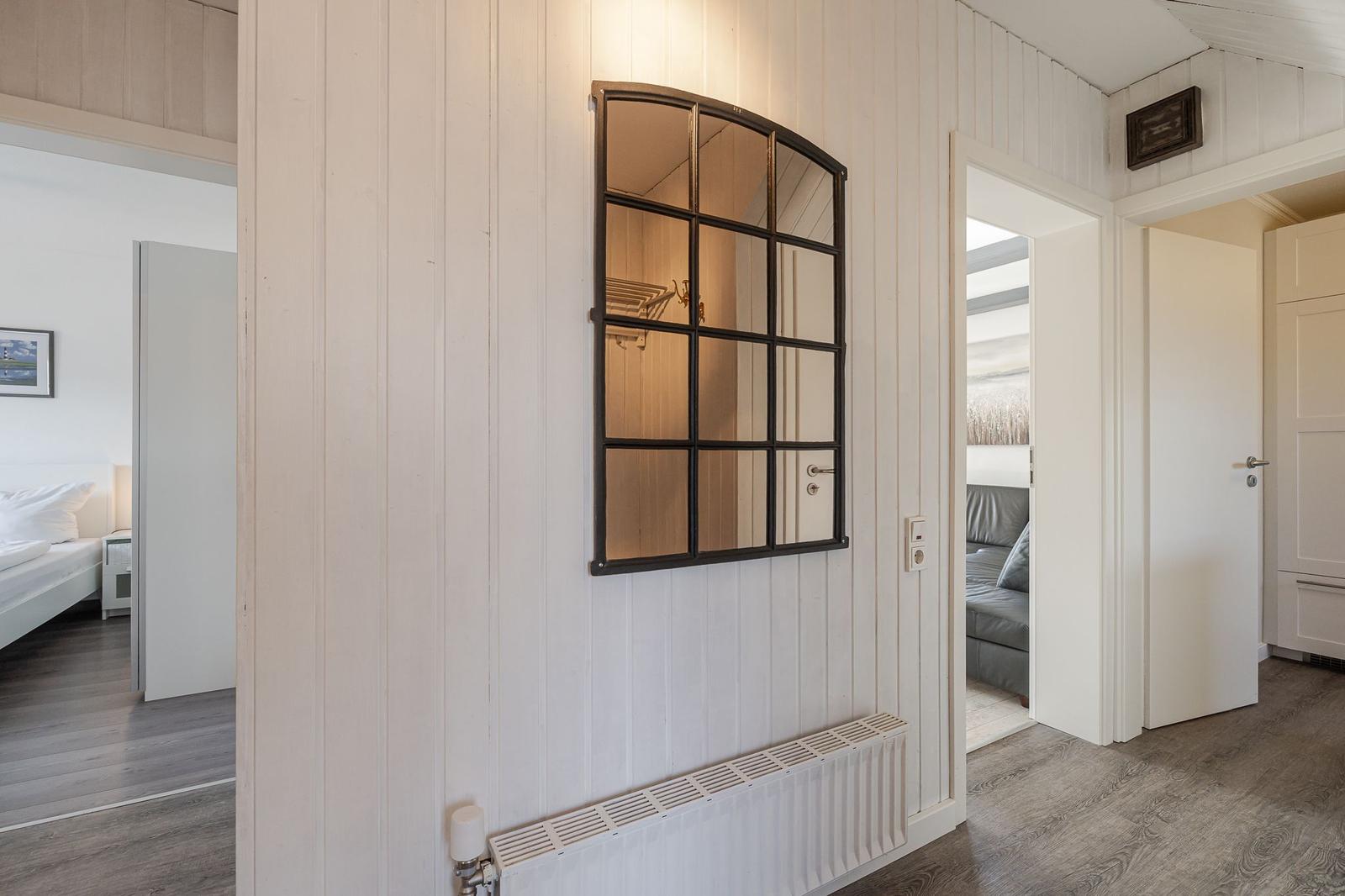 Hausflur mit Spiegel, Schlafzimmer und Wohnzimmer sichtbar