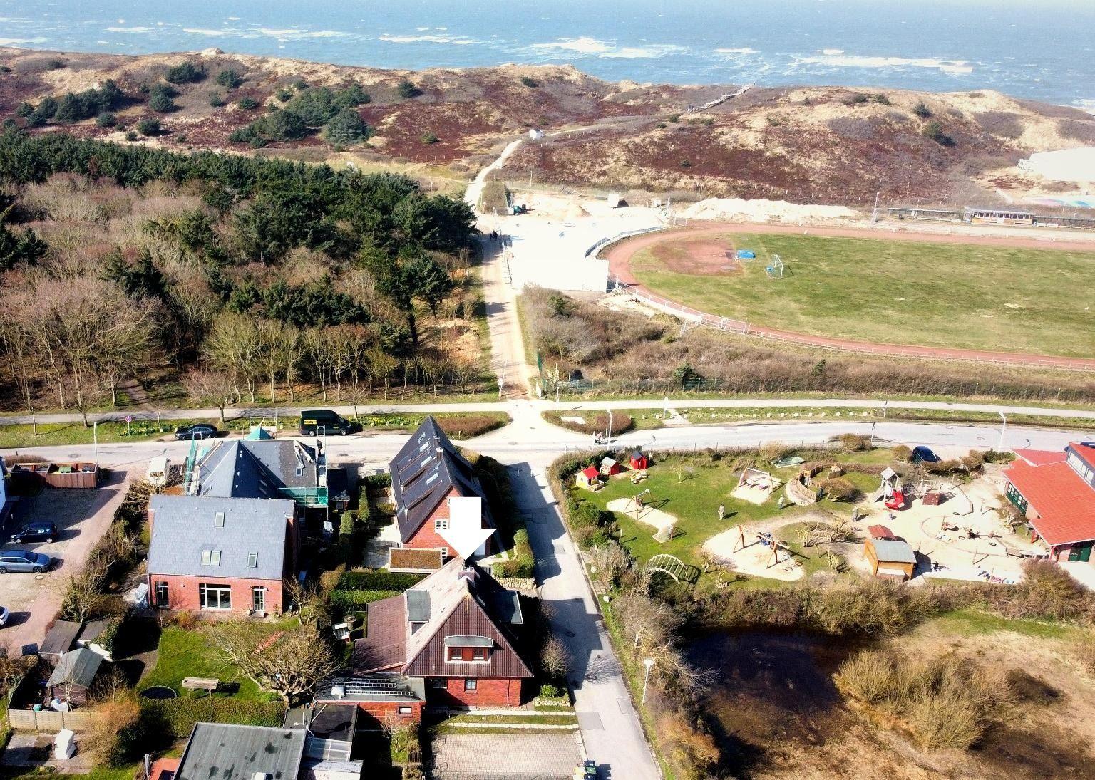 Haus mit Garten, Spielplatz und Blick auf die Dünen und den Strand.