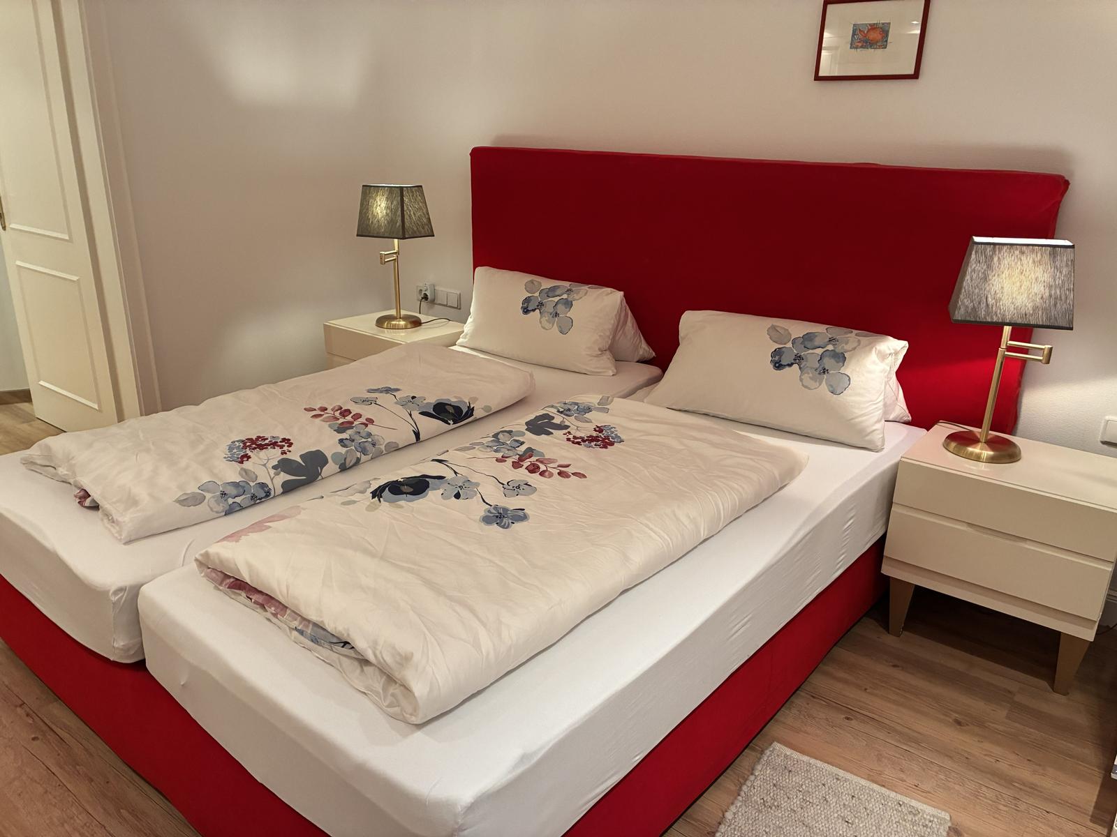 Ein Schlafzimmer mit einem Bett, zwei Nachttischen und Lampen.