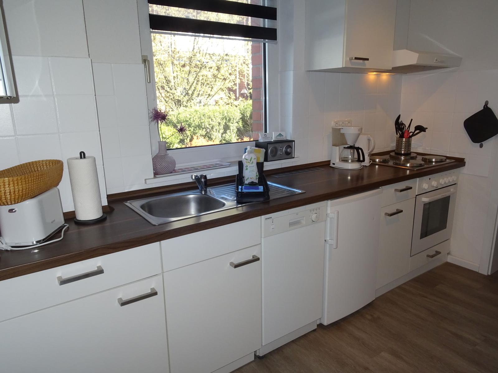 Küche mit Herd/Backofen, Kühlschrank, Spülmaschine, Kaffeemaschine, Toaster und Wasserkocher