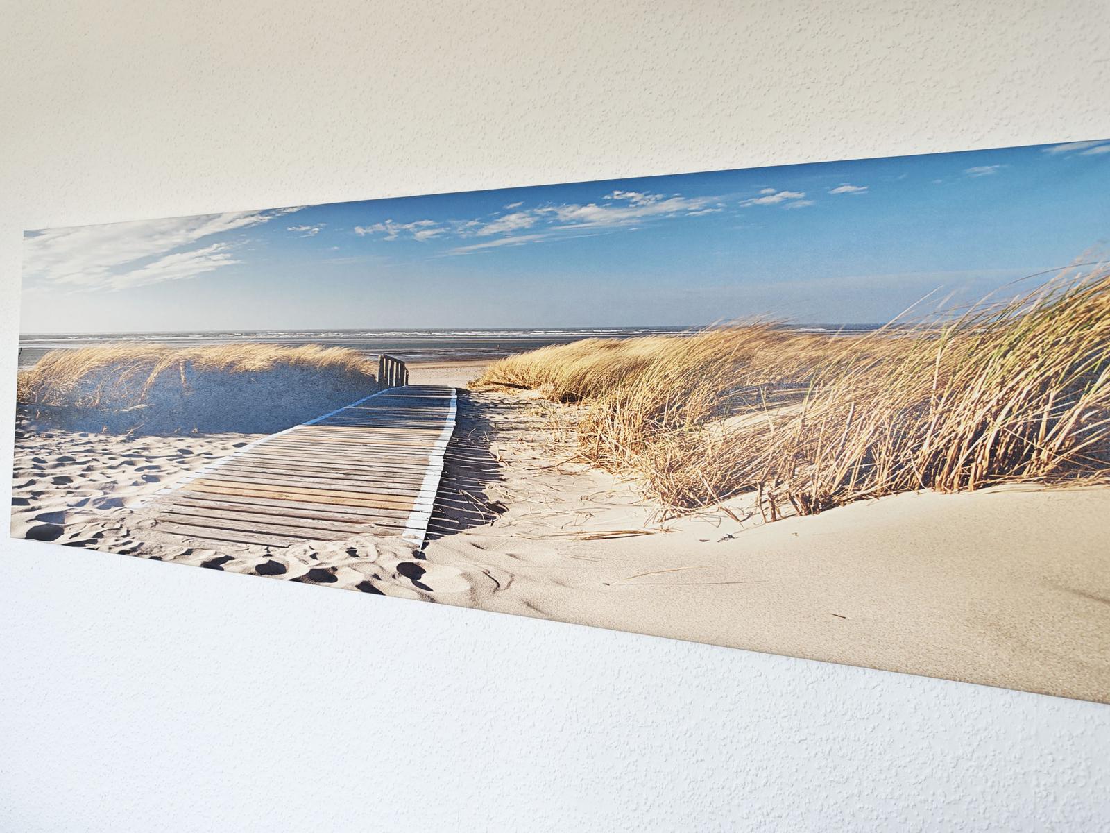 Panoramabild einer Holzbrücke durch Sanddünen zum Strand.