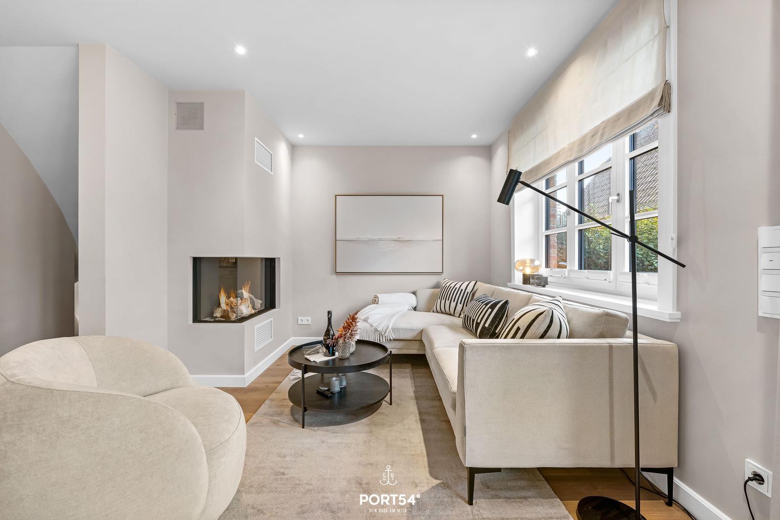 Wohnzimmer mit Sofa, Kamin und Tisch