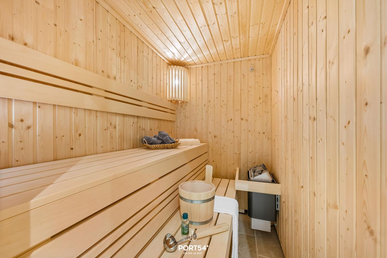 Sauna mit Holzbank, Eimer und Handtuch