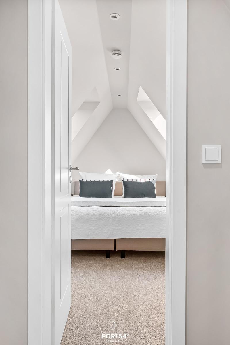 Schlafzimmer mit Dachschrägen, Bett und Fenster