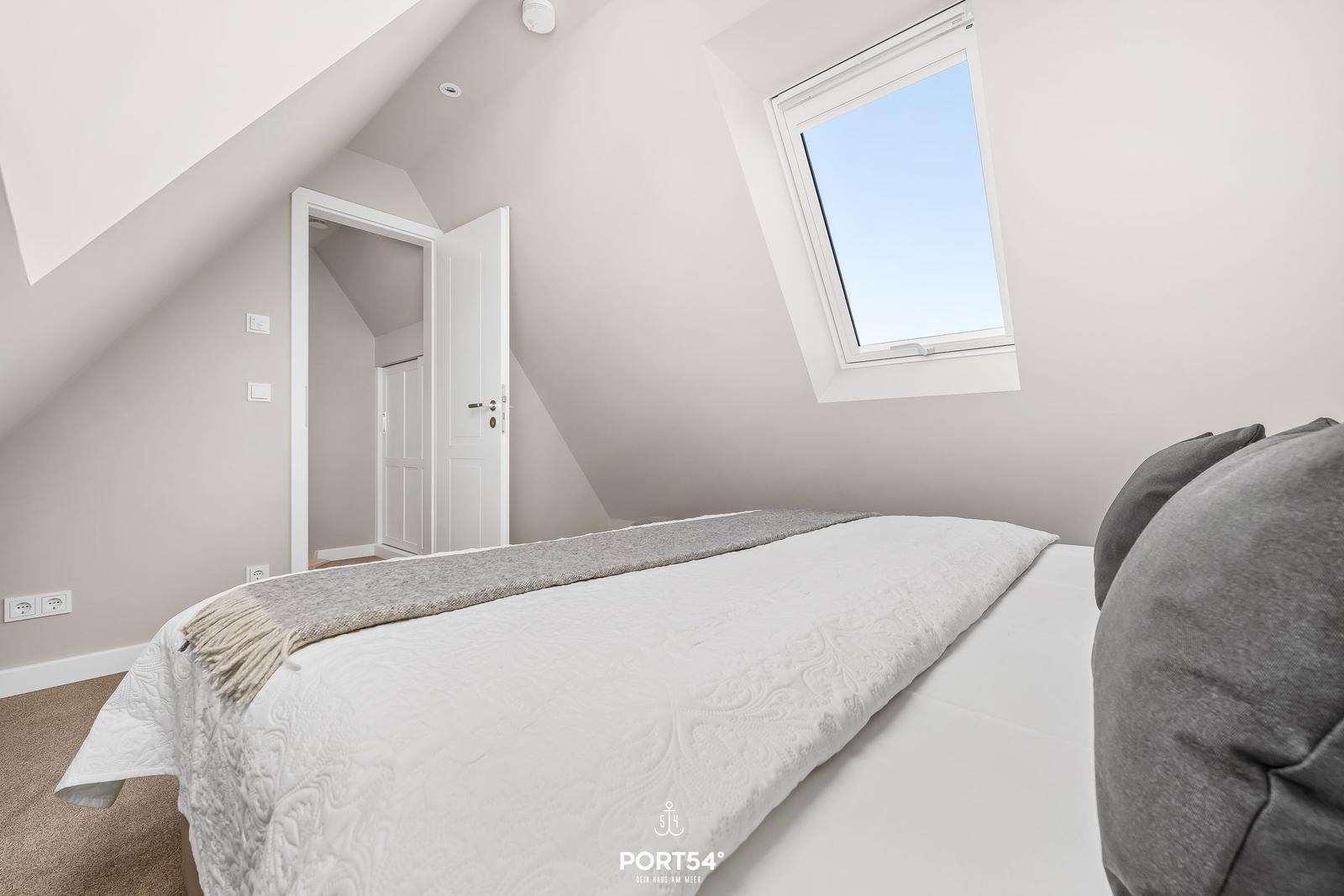 Schlafzimmer mit Dachfenster und Bett