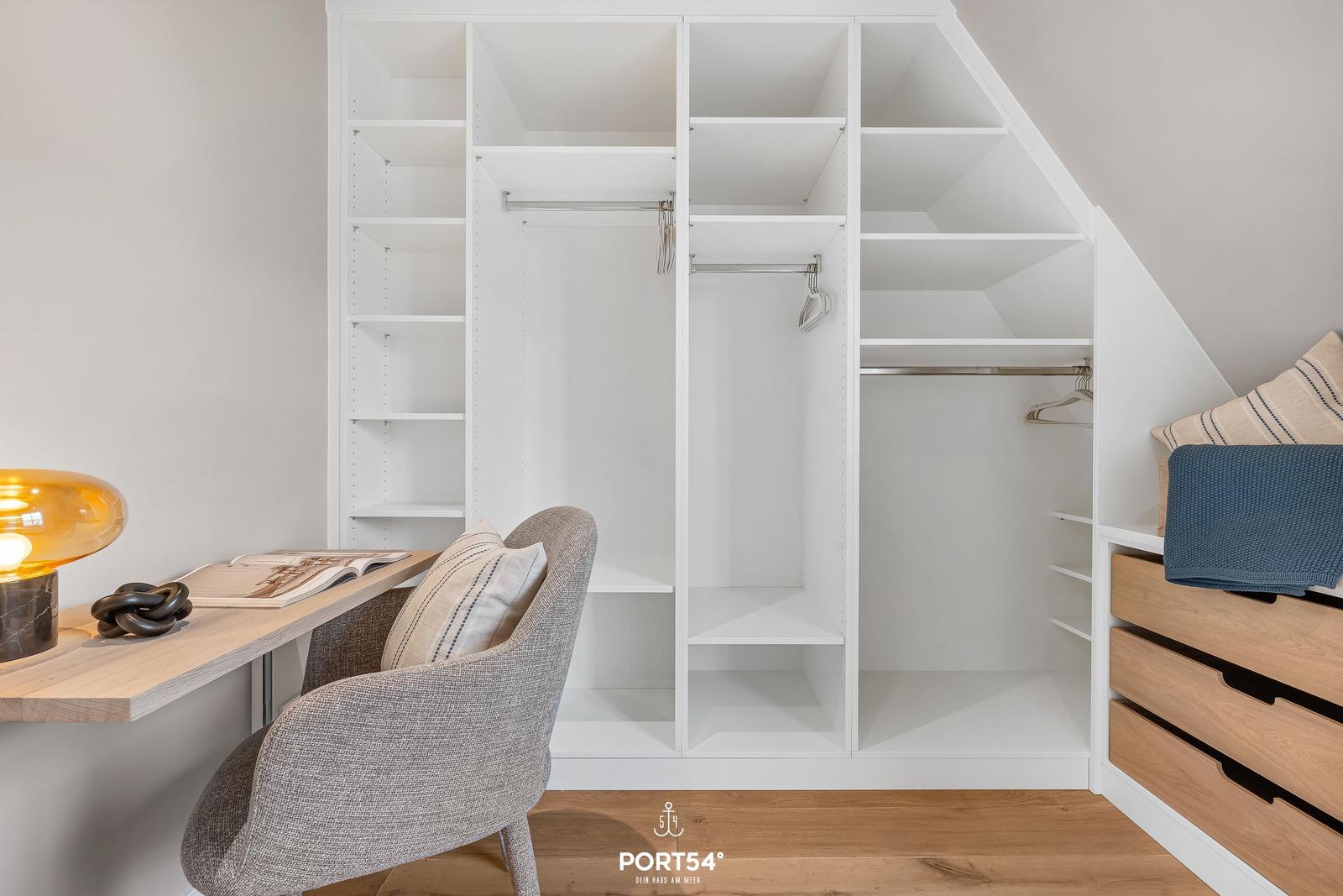 Schlafzimmer mit Kleiderschrank, Schreibtisch und Stuhl