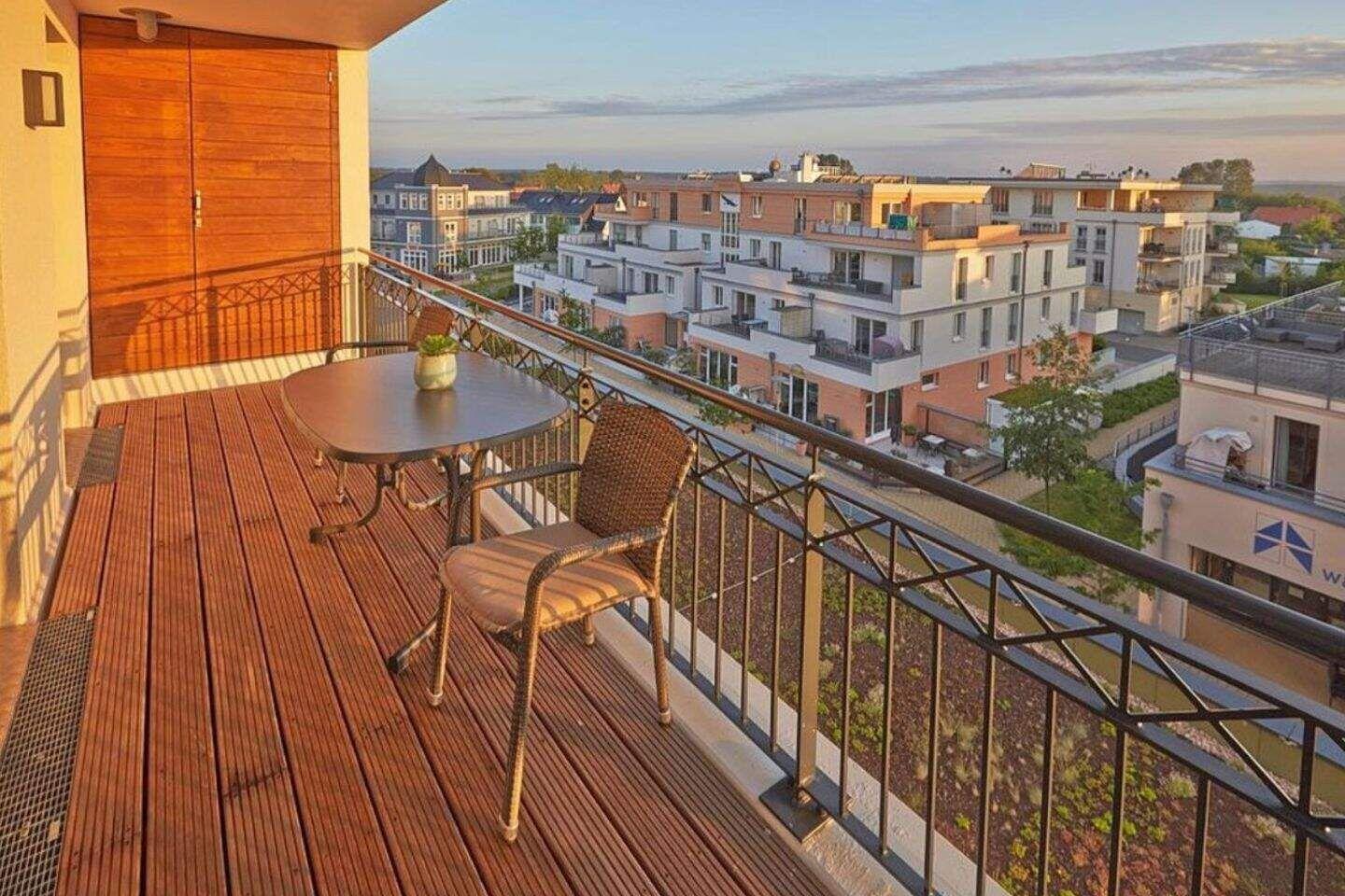 Terrasse mit Tisch und Stühlen, Blick auf Wohngebäude