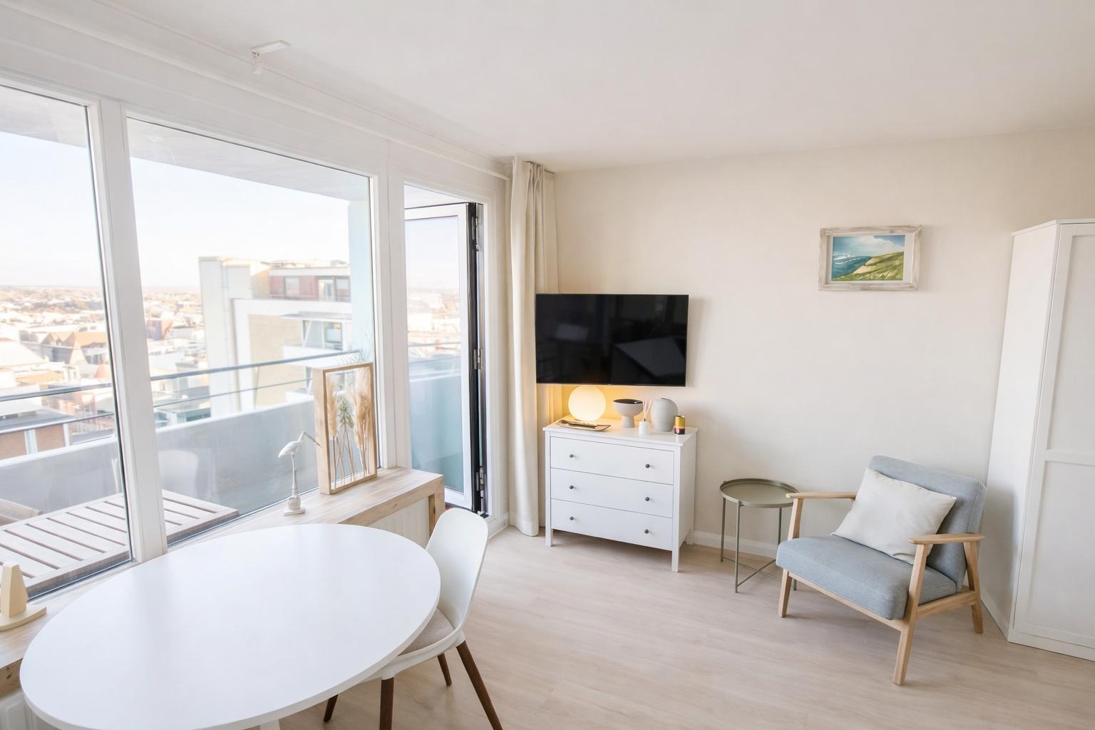 Wohnung mit Essbereich, TV und Sitzgelegenheit. Große Fenster mit Blick auf die Stadt.