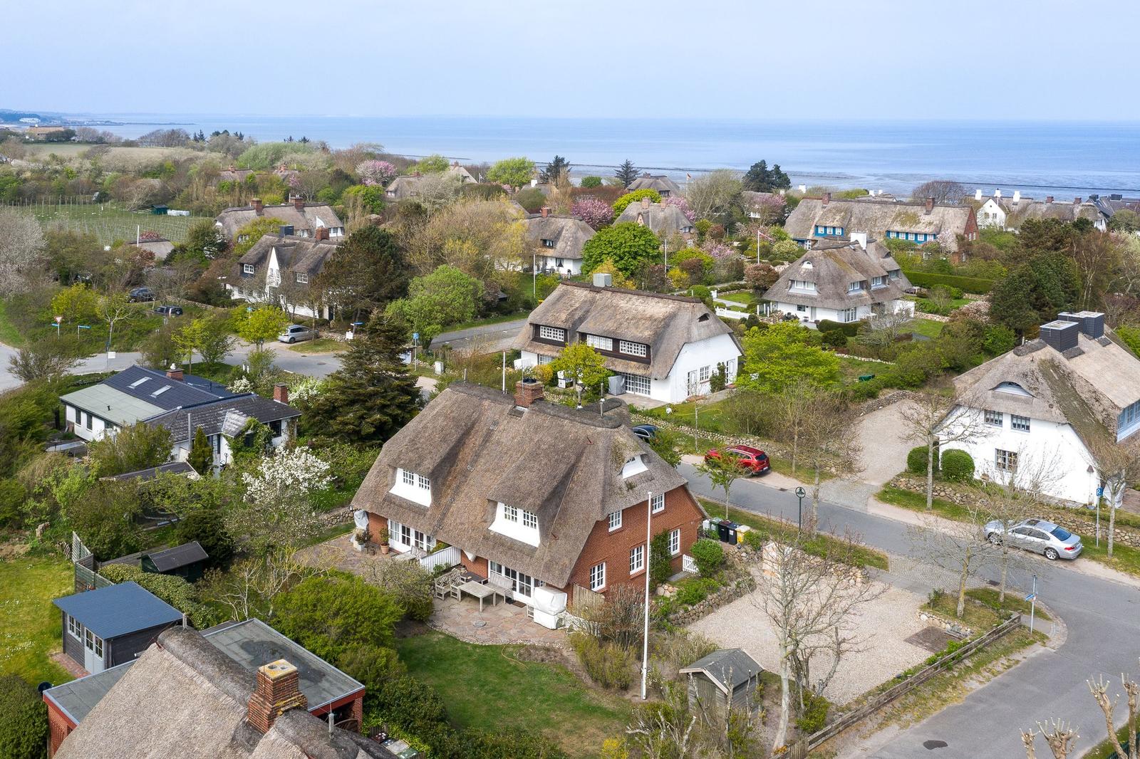 Dorf mit strohgedeckten Häusern und Blick aufs Meer